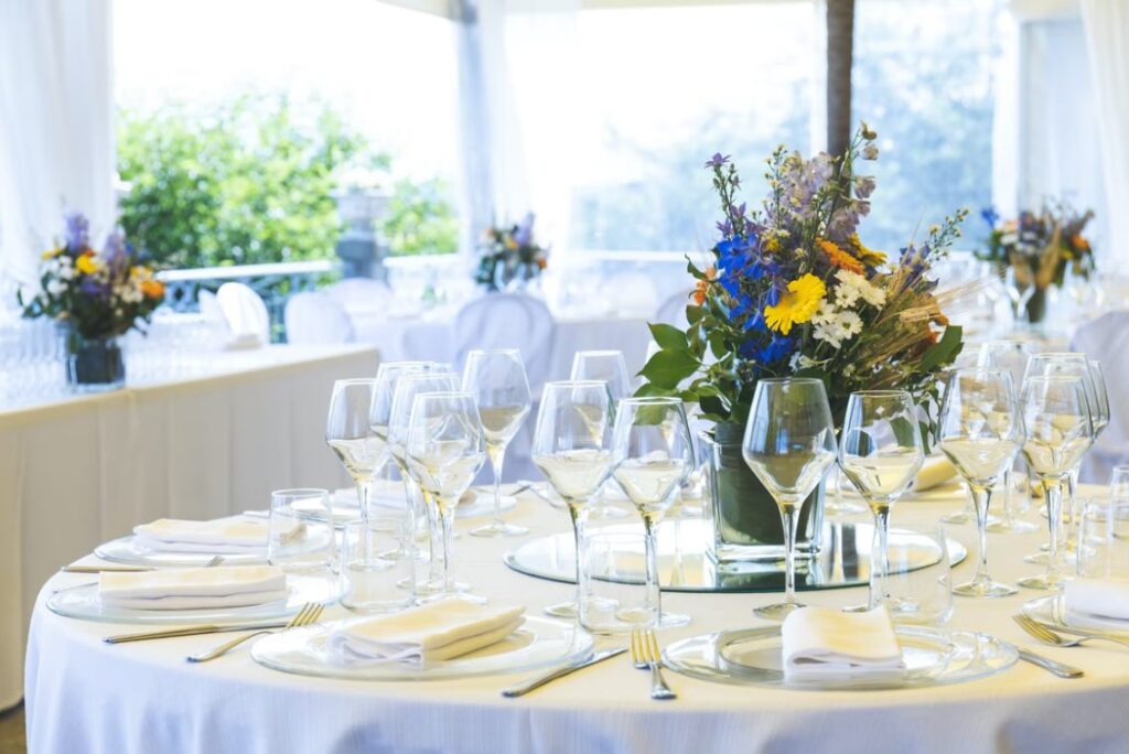 clear long-stem wine glasses on table near flower